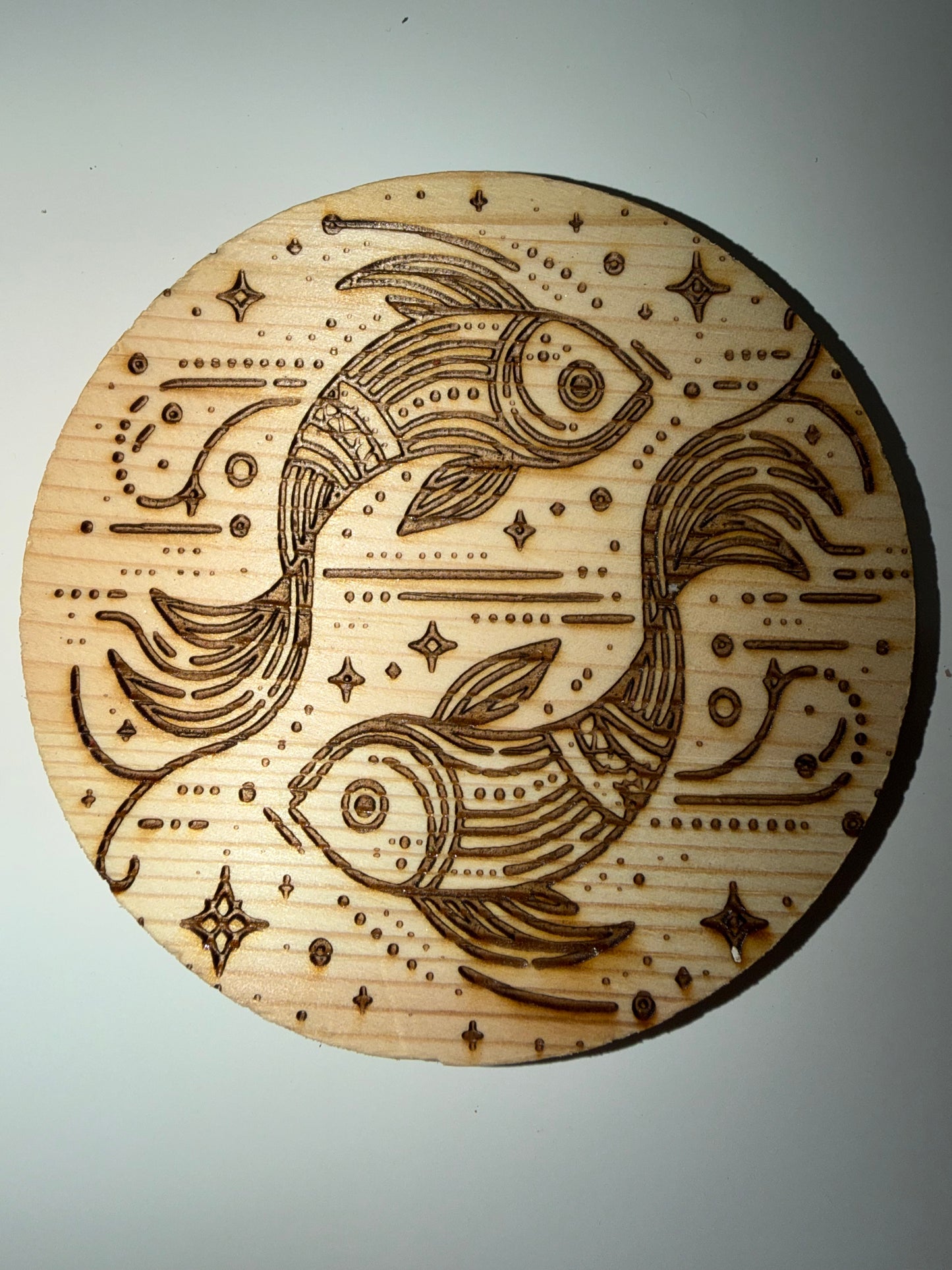 Circular wood Pisces pattern coaster